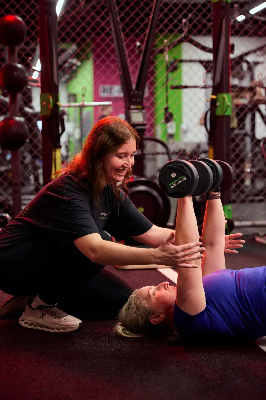 Personal trainer coaching client through dumbbell press at Archway Wellness Centre
