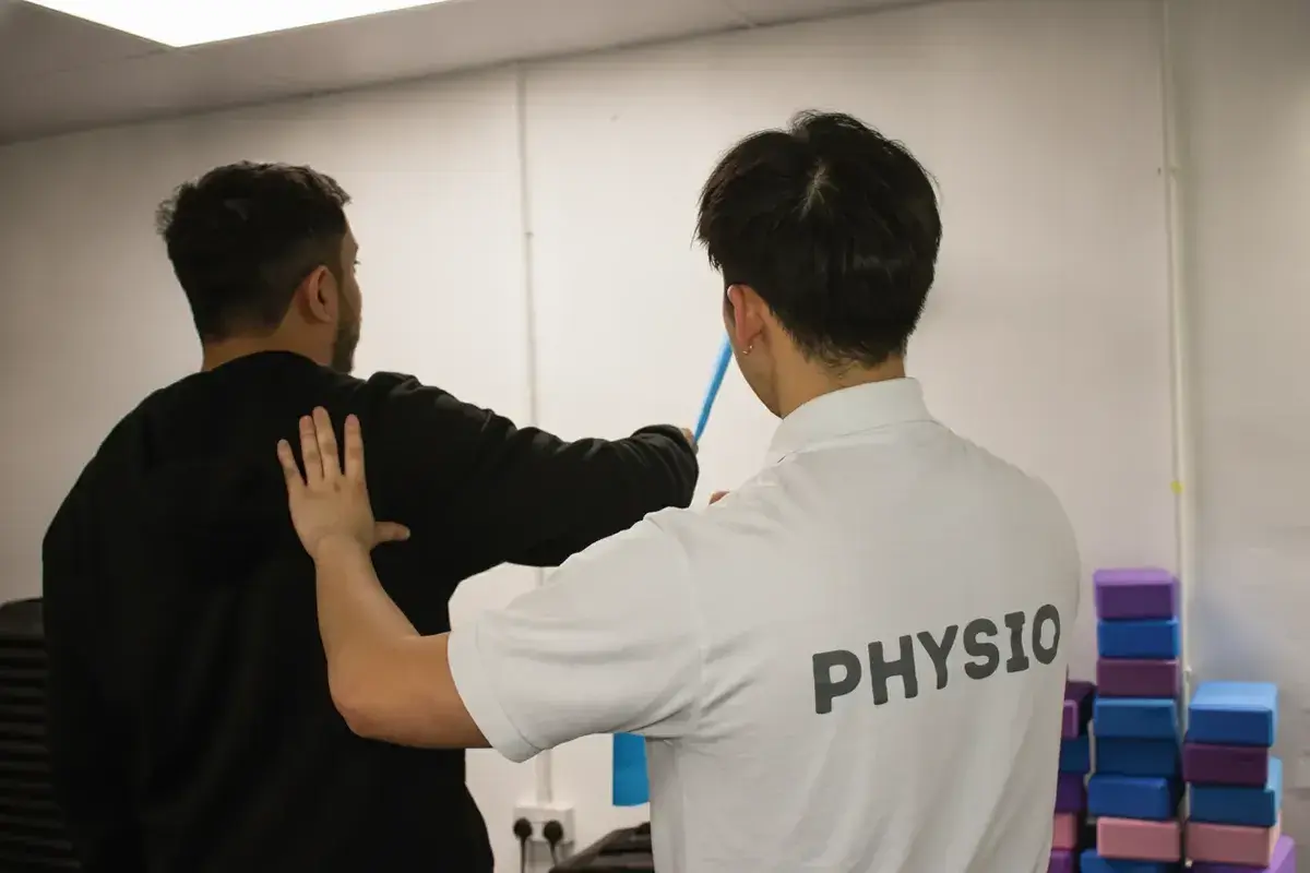 Patient performing guided shoulder rehabilitation exercises with physiotherapist