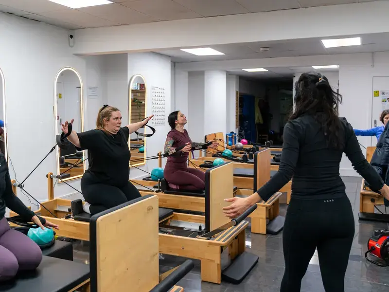 Instructor guiding a small reformer class at Archway Wellness Centre