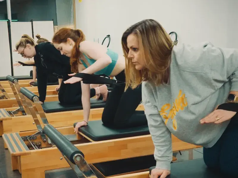 Kneeling single-arm strap pulls on the reformer