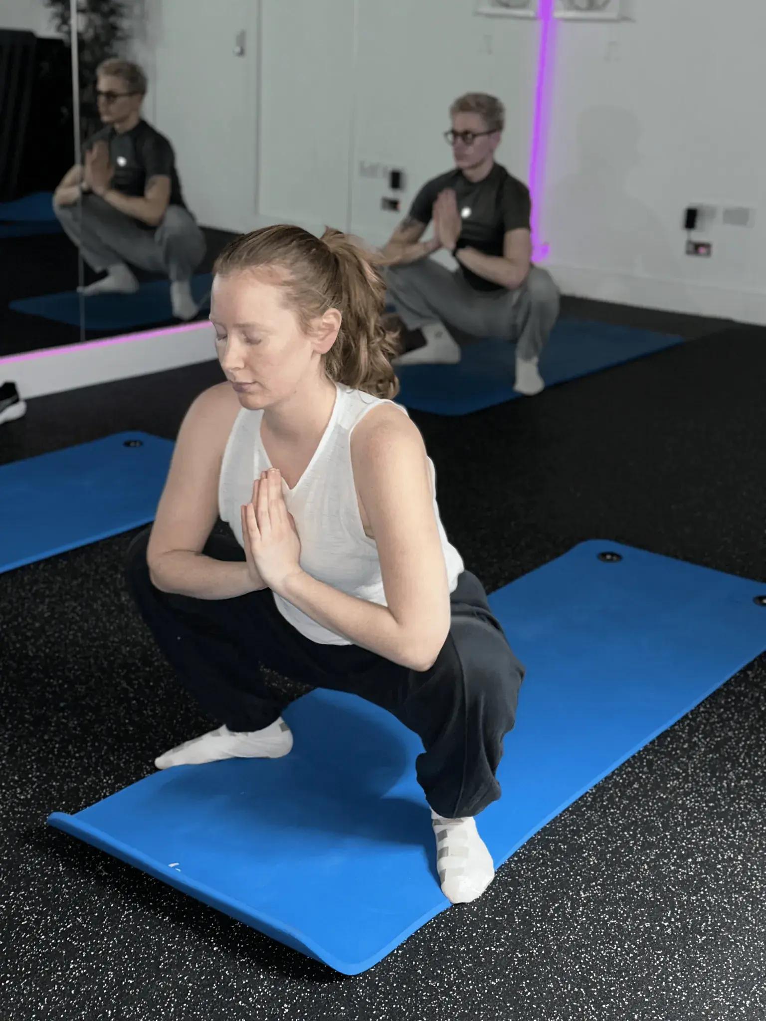 Yoga practitioner in malasana pose with prayer hands