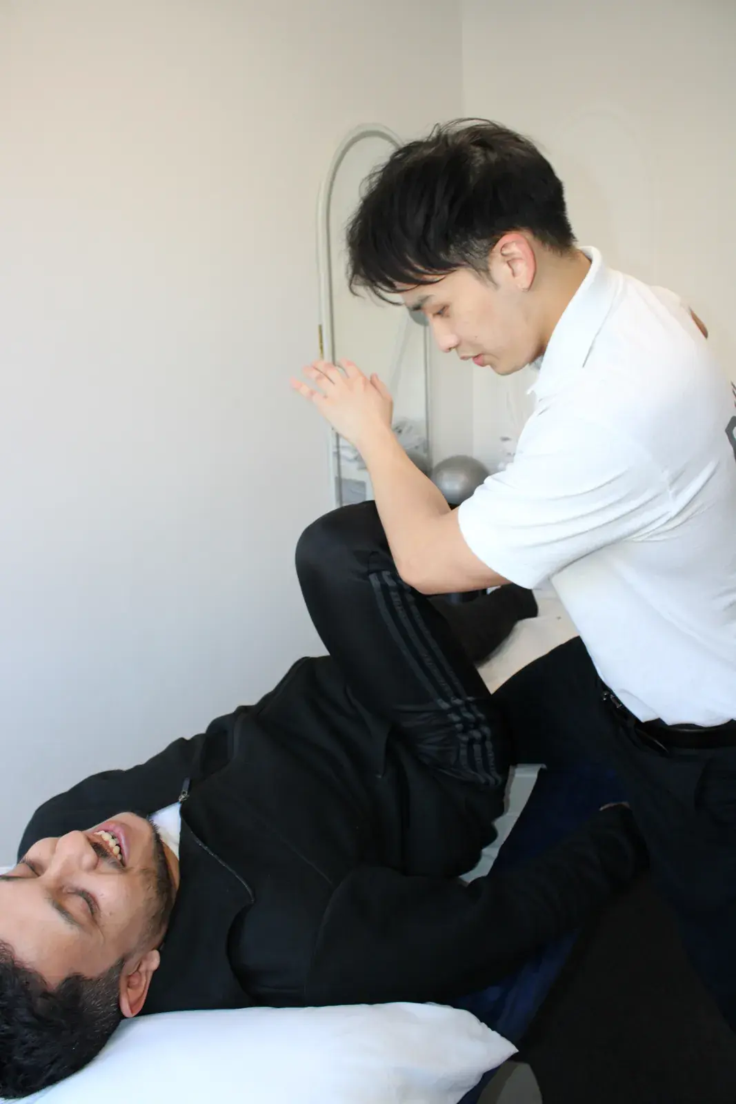 Knee-to-chest lower back stretch on the treatment couch