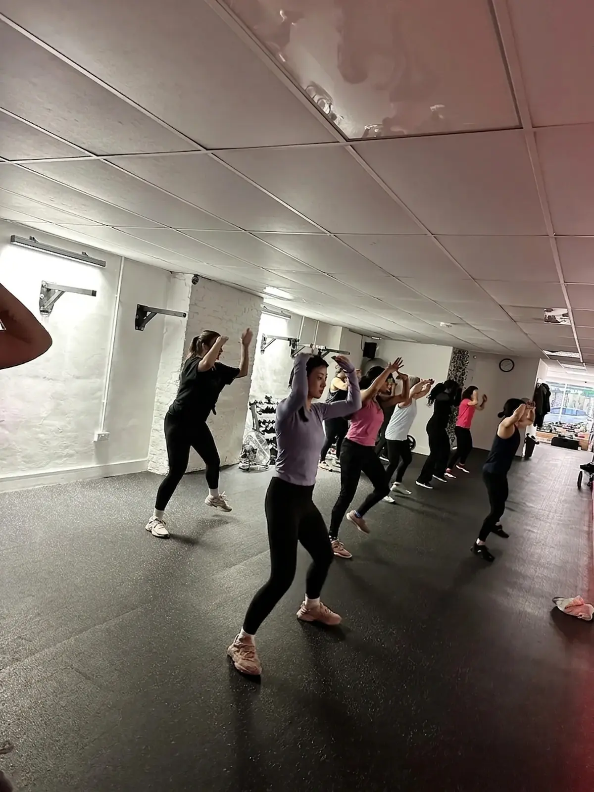 Zumba class raising their arms overhead mid-routine