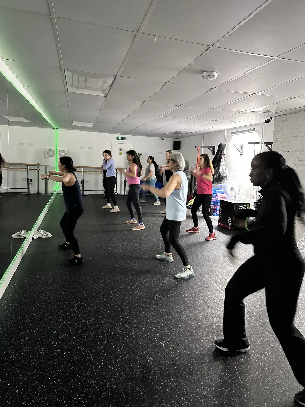 Zumba class dancing under the studio's coloured lighting