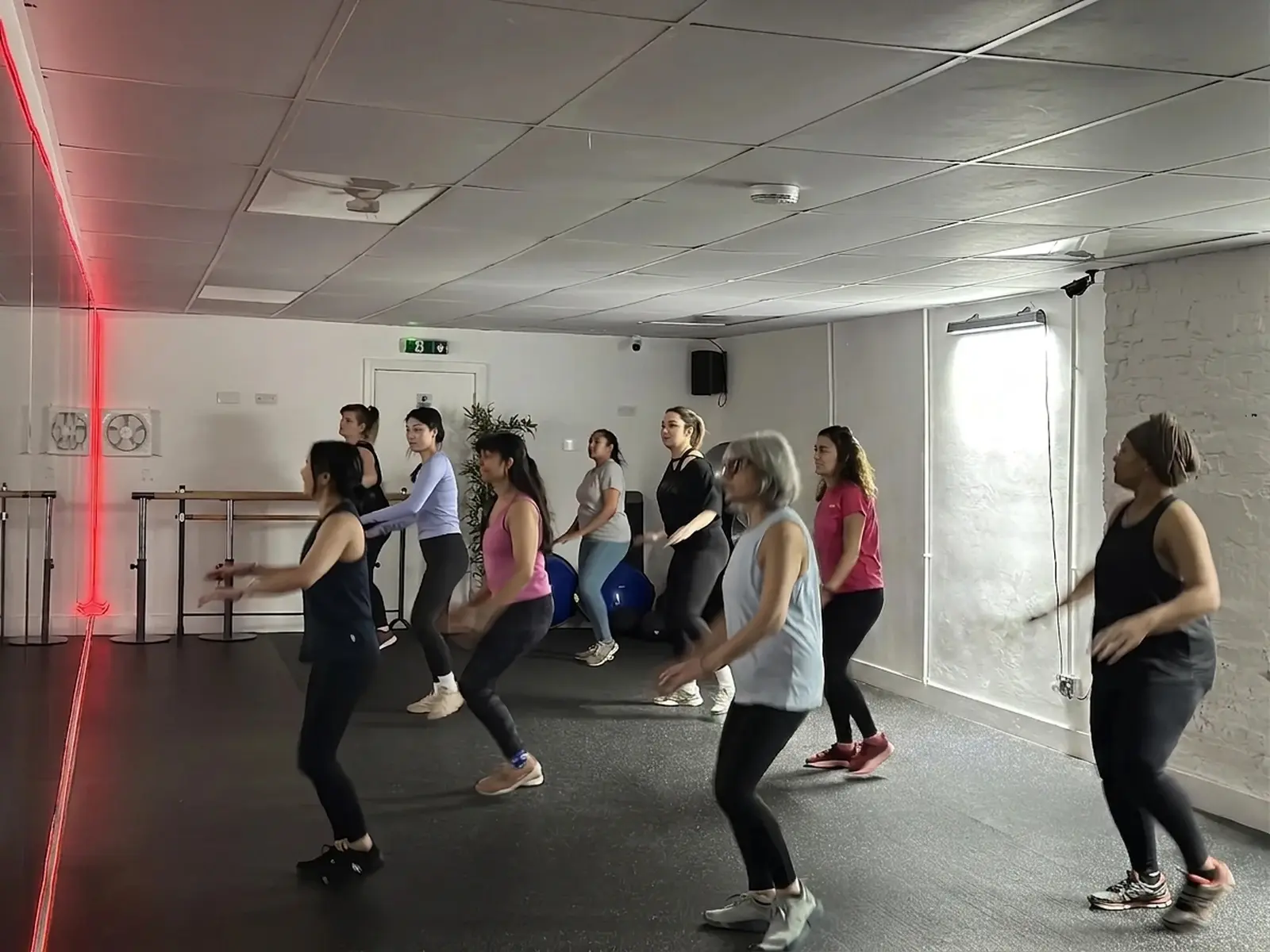 Zumba class dancing together under warm studio lighting at Archway Wellness Centre