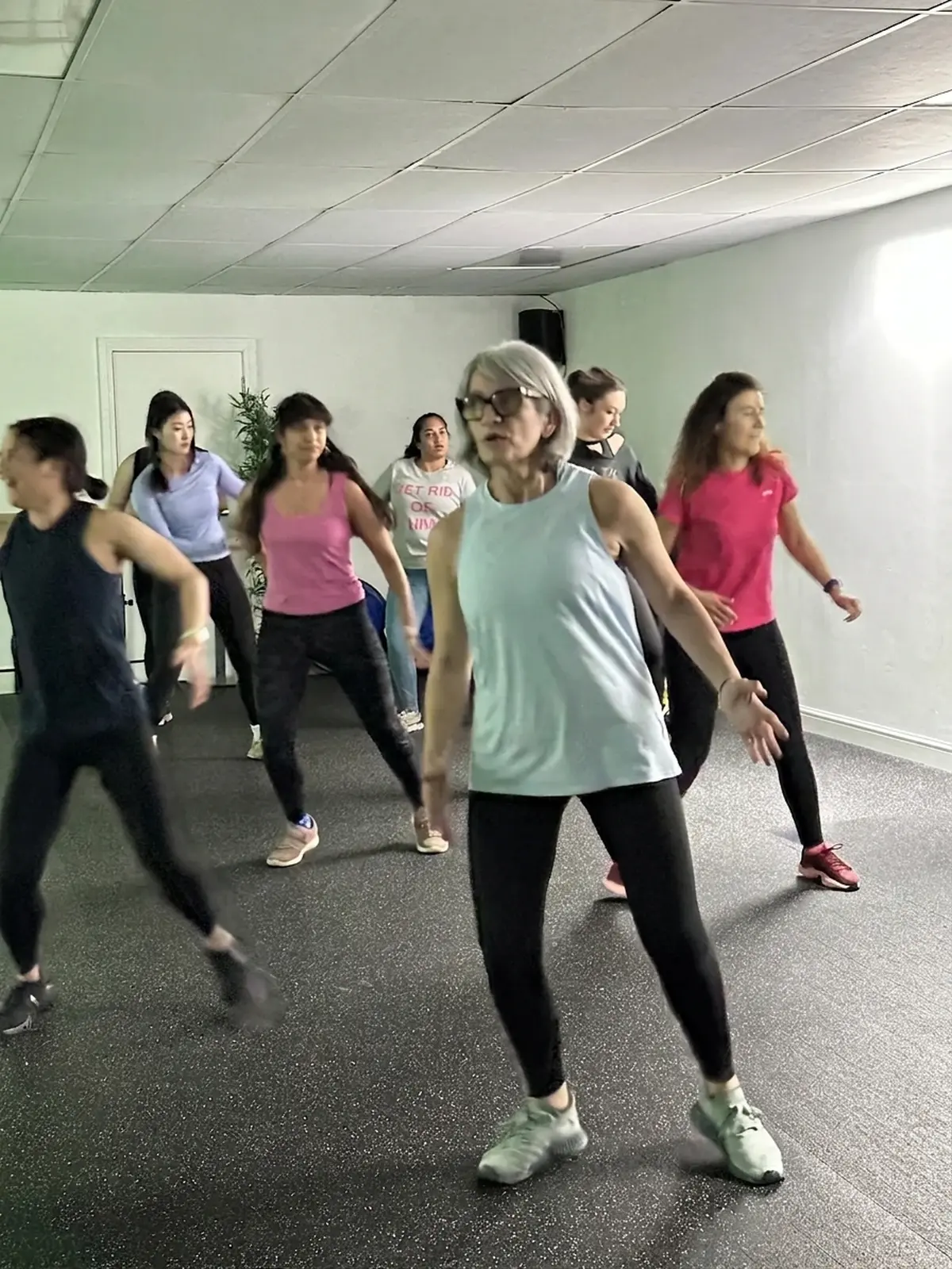 Zumba participant dancing confidently at the front of a class at Archway Wellness Centre
